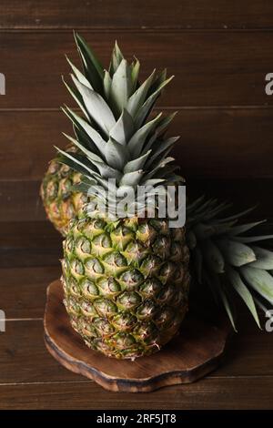 Deux ananas mûrs entiers sur une table en bois Banque D'Images