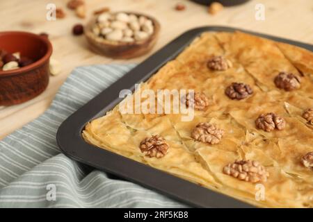 Délicieux baklava avec des noix dans une poêle à pâtisserie sur la table, closeup Banque D'Images