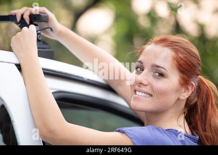 femme met des choses dans la galerie de toit Banque D'Images