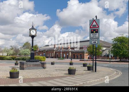 La vue d'élévation de face de l'ancienne gare et l'horloge sur un piédestal de brique sur un beau matin de printemps à Beverley, Yorkshire, Royaume-Uni. Banque D'Images