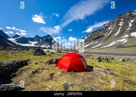 Tente rouge dans la vallée de Kaskasavagge, glacier et montagnes de Kaskapakte, montagne Kaskasatjakka et Kuopertjakka, rivière Gaskkasjohka, massif Kebnekaise Banque D'Images