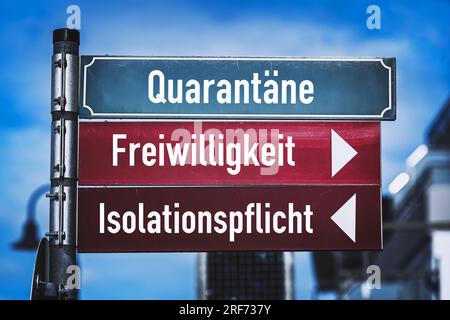 FOTOMONTAGE, Straßenschild mit Aufschrift Quarantäne, Freiwillikeit und Isolationspflicht Banque D'Images