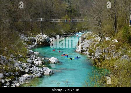 Kayakistes à la rivière Soca soufflent un pont en bois près de Kobarid en Slovénie au printemps Banque D'Images