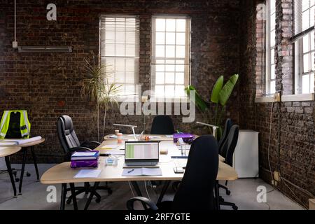 Intérieur de bureau moderne et créatif avec murs en briques apparentes, bureaux et chaises Banque D'Images