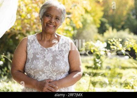 Portrait de femme biracial senior heureuse souriant dans le jardin ensoleillé à la maison, espace de copie Banque D'Images