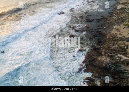 Vue aérienne de la mer sur un rivage rocheux à l'aube Banque D'Images