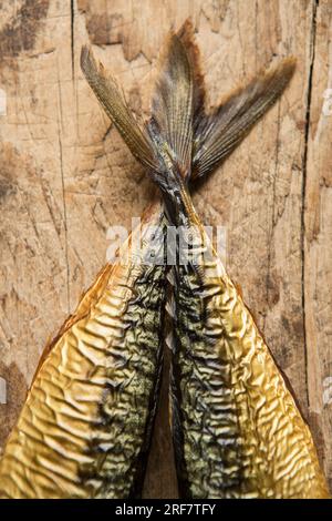 Deux maquereaux fumés chauds, Scomber scombrus sur une planche à découper en bois qui sera utilisé pour faire un pâté de maquereau maison. Angleterre Royaume-Uni GB Banque D'Images