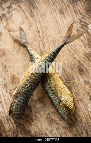 Deux maquereaux fumés chauds, Scomber scombrus sur une planche à découper en bois qui sera utilisé pour faire un pâté de maquereau maison. Angleterre Royaume-Uni GB Banque D'Images