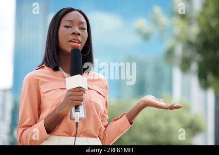 Journaliste féminine noire filmant une vidéo documentaire ou un reportage Banque D'Images