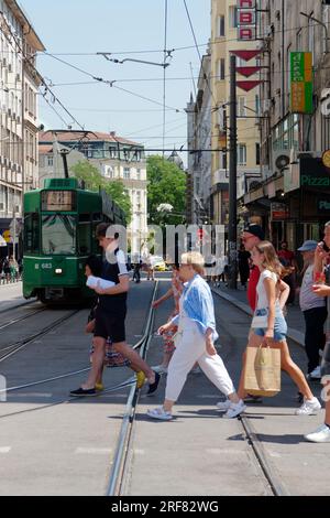 Les gens traversent la route devant un tramway vert aka Streetcar aka Trolley dans une rue de la ville de Sofia, Bulgarie. 01 août 2023. Banque D'Images