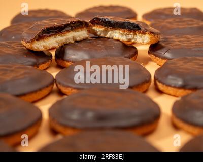 Biscuits au chocolat noir et marmelade d'orange. Biscuits au chocolat noir sur fond orange. Banque D'Images