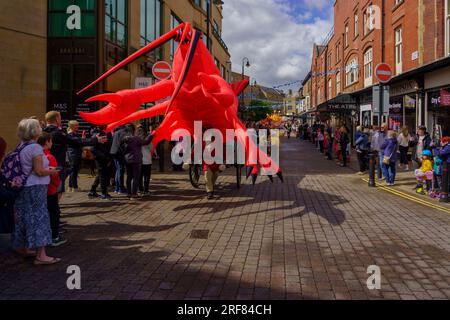 Un gigantesque homard gonflable rouge attire les spectateurs dans le centre-ville à la Harrogate Carnival Parade dans le North Yorkshire, Angleterre, Royaume-Uni. Banque D'Images