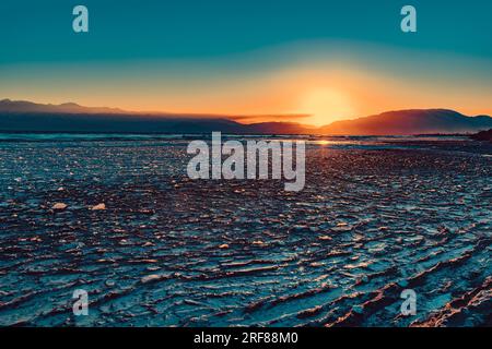 Eau gelée dans le lac par temps froid d'hiver, lumière du coucher du soleil, Kirghizistan, Issyk-Kul Banque D'Images