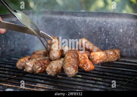 Barbecue Grill dans l'arrière-cour de campagne, préparer, griller cevapcici (plat traditionnel des Balkans populaire en Serbie et en Bosnie et la région) Banque D'Images