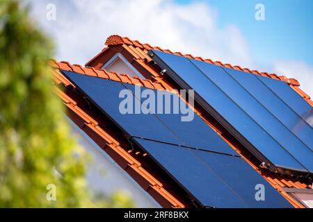 Gros plan de panneaux pour l'énergie solaire thermique sur le toit d'un bâtiment résidentiel Banque D'Images