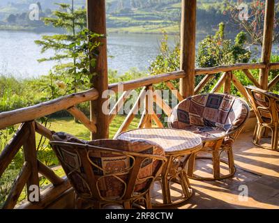 Une table basse en bois avec des chaises sur une terrasse en bois près du lapin du lac ougandais Banque D'Images
