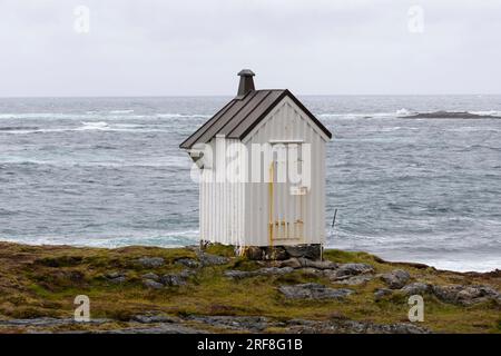 Petite maison blanche à côté de Børhella fyr brave le vent et la mer orageuse. Nøss, Andenes, Andøya, Vesterålen, Nordland, Norvège du Nord Banque D'Images