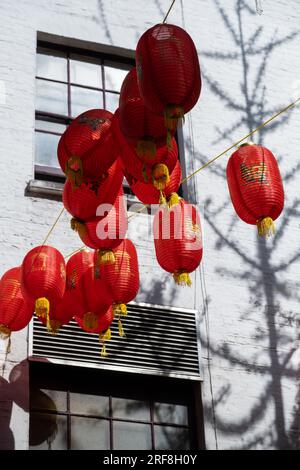 Des lanternes chinoises sont suspendues au-dessus d'une rue dans Chinatown, Londres, Angleterre. Banque D'Images