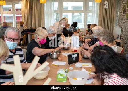 Atelier culinaire dans une résidence de service senior, animation, préparation et dégustation de biscuits au sirop d'érable. Banque D'Images