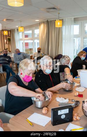 Atelier culinaire dans une résidence de service senior, animation, préparation et dégustation de biscuits au sirop d'érable. Banque D'Images