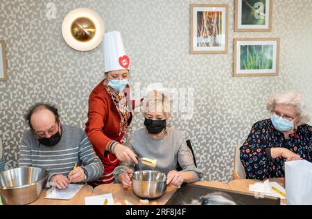 Atelier culinaire dans une résidence de service senior, animation, préparation et dégustation de biscuits au sirop d'érable. Banque D'Images