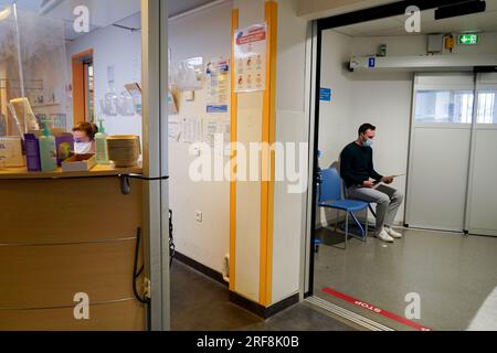 Patient dans la salle d'urgence d'un hôpital universitaire. Ce jeune homme pense qu'il a été drogué sans sa connaissance dans un bar. Banque D'Images