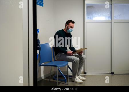 Patient dans la salle d'urgence d'un hôpital universitaire. Ce jeune homme pense qu'il a été drogué sans sa connaissance dans un bar. Banque D'Images
