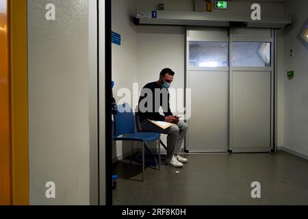 Patient dans la salle d'urgence d'un hôpital universitaire. Ce jeune homme pense qu'il a été drogué sans sa connaissance dans un bar. Banque D'Images