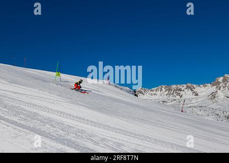 Falcade, Italie - 15 février 2023 : piste de ski avec skieur sous ciel bleu. Les gens descendent les montagnes enneigées à skis. Groupe de skieurs sur une piste de ski Banque D'Images
