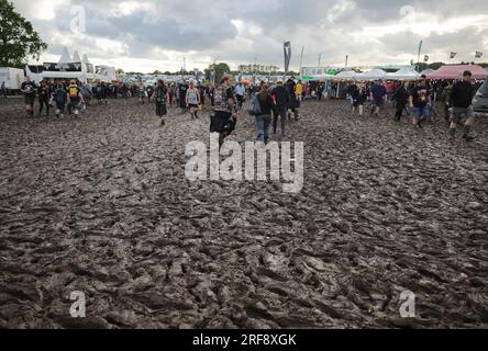 Wacken, Allemagne. 01 août 2023. Les fans de métal sont sur le terrain du festival trempé et boueux de pluie. Le Wacken Open-Air (WOA) du 2 au 5 août est considéré comme le plus grand festival de heavy Metal au monde et est épuisé avec 85 000 000 visiteurs. Crédit : Christian Charisius/dpa/Alamy Live News Banque D'Images