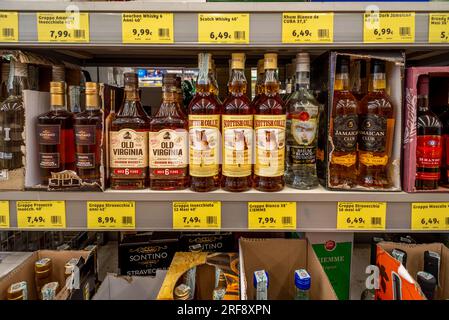 Italie - 29 juillet 2023 : whisky écossais, whisky bourbon et rhum en bouteilles présentés sur l'étagère pour la vente à bas prix dans les magasins discount italiens Banque D'Images