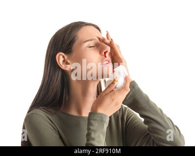 Jeune femme avec saignement de nez et tissu sur fond blanc, gros plan Banque D'Images