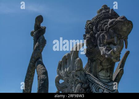 Statues balinaises en pierre sur l'eau dans le Lake Water Palace Tirta Gangga à Bali, Indonésie Banque D'Images