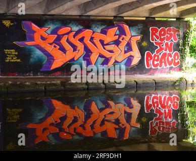Art mural sous un pont routier à côté du canal Bridgewater, avec reflet d'œuvres d'art dans l'eau, section Stretford ; l'artiste l'a dédié à « son homie, Pingu, disparu mais pas oublié » Banque D'Images