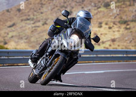 le motocycliste prend une courbe nette sur sa moto. Photographie prise dans le port de Navalmoral, province de la ville d'Avila, Espagne, pendant la journée Septem Banque D'Images