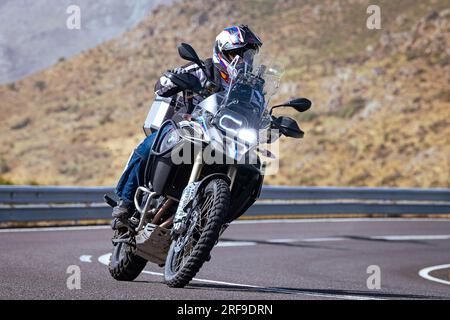 le motocycliste prend une courbe nette sur sa moto. Photographie prise dans le port de Navalmoral, province de la ville d'Avila, Espagne, pendant la journée Septem Banque D'Images