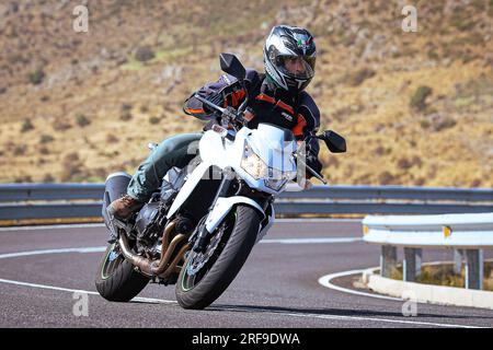 le motocycliste prend une courbe nette sur sa moto. Photographie prise dans le port de Navalmoral, province de la ville d'Avila, Espagne, pendant la journée Septem Banque D'Images