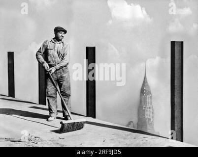 New York, New York : c. 1931. Un ouvrier balayant le trottoir le plus haut du monde, le 81e étage de l'Empire State Building, le plus haut bâtiment du monde, au sommet duquel le plus grand dirigeable 'Los Angeles' tentera de s'amarrer. Cette photo a été prise à 1 248 pieds au-dessus du niveau de la rue. Banque D'Images