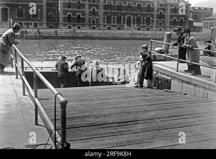 New York, New York : 7 mai 1926 photo montre des déportés quittant Ellis Island pour le navire qui les ramènera sur leurs terres natales. Les immigrants qui arrivent sont examinés de près sur l'île, et tous ne sont pas autorisés à rester. Banque D'Images