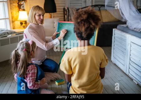 Éducation, concept de maternelle. Groupe d'enfants d'âge préscolaire à l'écoute de l'enseignant. Banque D'Images