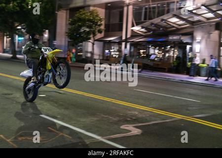 Seattle, États-Unis. 11 juillet 2023. Une moto faisant un wheelie au centre-ville tôt dans la soirée sur 1st ave. Banque D'Images
