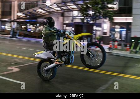Seattle, États-Unis. 11 juillet 2023. Une moto faisant un wheelie au centre-ville tôt dans la soirée sur 1st ave. Banque D'Images
