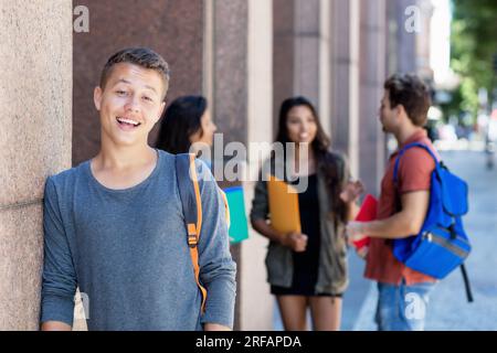 Bel étudiant masculin autrichien avec groupe de jeunes adultes en plein air dans la ville en été Banque D'Images