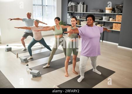 Instructeur montrant des exercices aux personnes pendant l'entraînement sportif en classe Banque D'Images
