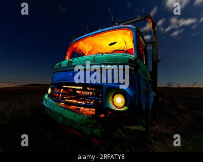 Camion vieux et abandonné dans le capmo la nuit et éclairé avec des lumières LED Banque D'Images