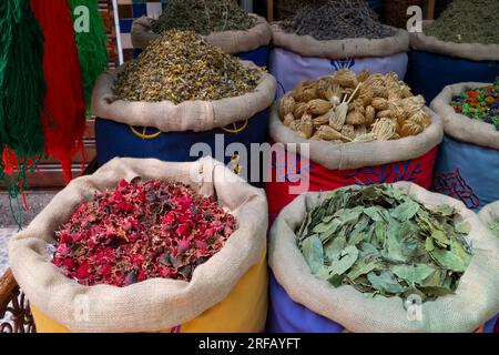 Maroc : dans le sens des aiguilles d'une montre en partant du bas à gauche, fleurs d'œillet séchées, fleurs de camomille, bushnika (fleur de cure-dent) et Laurier chez un marchand d'herbes et d'épices, quartier du Souk, Médina de Marrakech, Marrakech. Marrakech a été fondée en 1070 par l'émir Abu Bakr ibn Umar en tant que capitale impériale de l'Empire almoravide. Les Almoravides ont établi les premières structures majeures de la ville, qui a rapidement grandi et s'est imposé comme un centre culturel, religieux et commercial pour le Maghreb. Banque D'Images