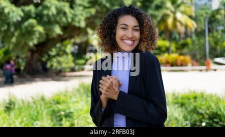 Belle femme d'affaires latino-américaine avec blazer bleu en plein air dans la ville en été Banque D'Images