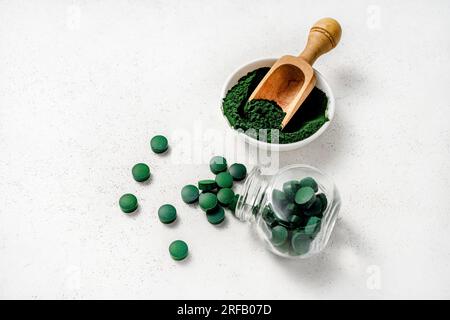 Spiruline algues poudre et Spiruline comprimés sur fond blanc. Banque D'Images