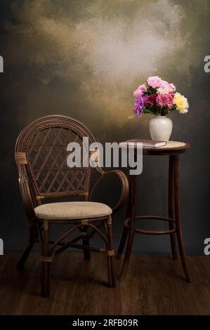 Une belle zone photo dans un studio photo pour les séances photo. Zone photo vintage pour portrait avec chaise de campagne et table. Vase avec des fleurs sur le tabl Banque D'Images