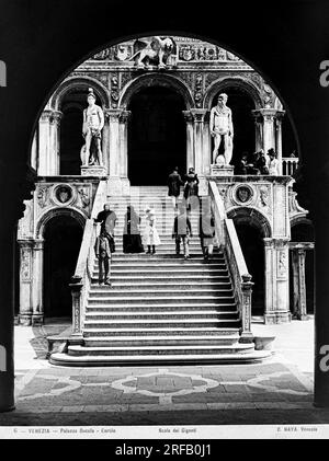 Venise - 1870 ca les visiteurs marchent à travers la 'Scala dei Giganti' dans la cour du Palais Ducale. Conçue par Antonio Rizzo entre 1483 et 1485, la Scala a été achevée en 1491 dans la partie sculpturale. Le nom dérive des deux statues de pierre avec Mars et Neptune sculptées par Jacopo Sansovino et placées sur le parapet supérieur en 1576. Image appartenant aux archives Naya-Bohm, série 'vues'. Venezia - 1870 CA i visitatori passeggiano nella 'Scala dei Giganti' nel cortile di Palazzo Ducale. Progettato da Antonio Rizzo tra il 1483 e il 1485, la Scala fu completata nel 1491 nella parte scul Banque D'Images